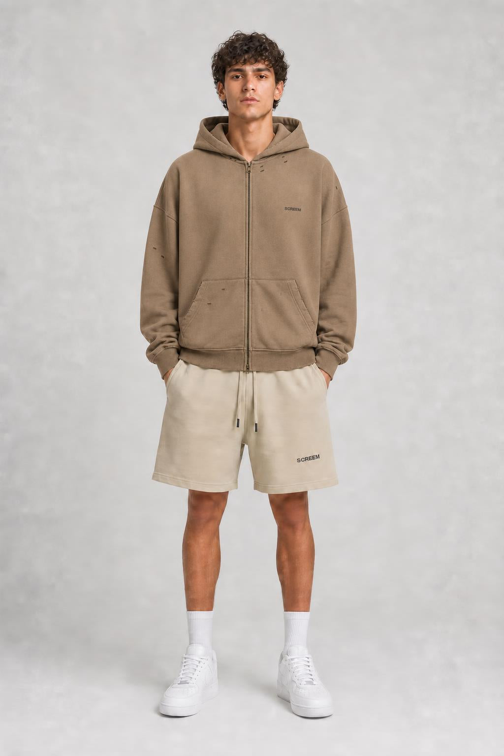 Model wearing SCREEM shorts with camel full-zip hoodie, front view