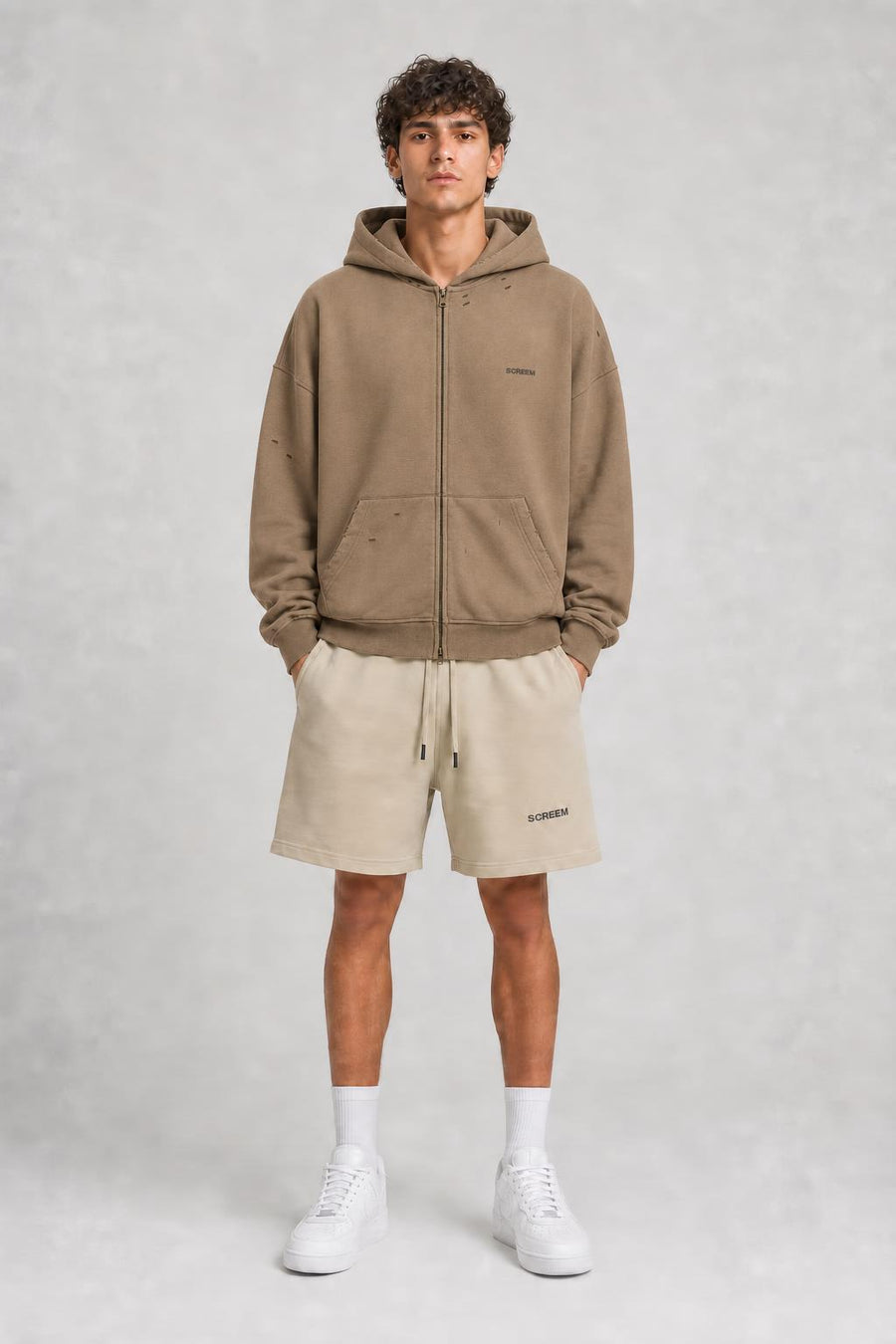 Model wearing SCREEM shorts with camel full-zip hoodie, front view