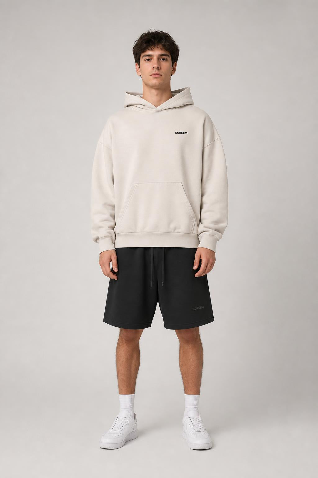 Model wearing SCREEM Basic Hoodie with black shorts, front view