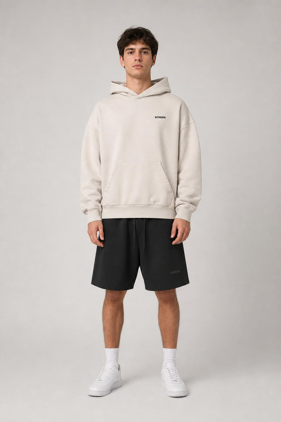 Model wearing SCREEM Basic Hoodie with black shorts, front view